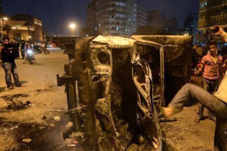 
	Manifestantes atacam carro da pol&iacute;cia ap&oacute;s dist&uacute;rbios na cidade do Cairo: nos arredores destes edif&iacute;cios ocorrem confrontos entre manifestantes e policiais
 (Khaled Desouki/AFP)