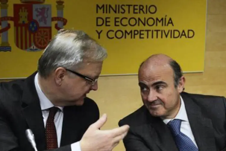 
	O comiss&aacute;rio europeu Olli Rehn conversa com o ministro da Economia da Espanha, Luis de Guindos: ao mesmo tempo, a CE n&atilde;o v&ecirc; necessidade de ajudar mais o banco espanhol
 (Pierre-Philippe Marcou/AFP)