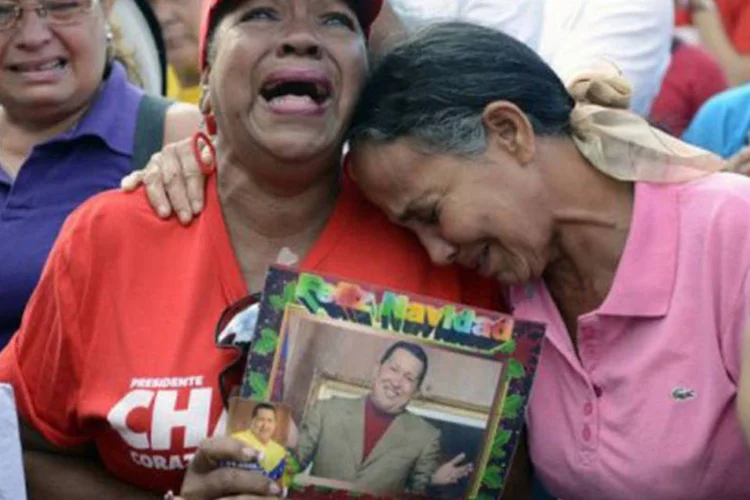 
	Hospital militar de Caracas: crian&ccedil;as, adultos e idosos acompanharam a comitiva f&uacute;nebre com bandeiras venezuelanas, fotos, p&ocirc;steres e camisas com imagens de Ch&aacute;vez, gritando mensagens de apoio ao governo
 (Leo Ramirez/AFP)