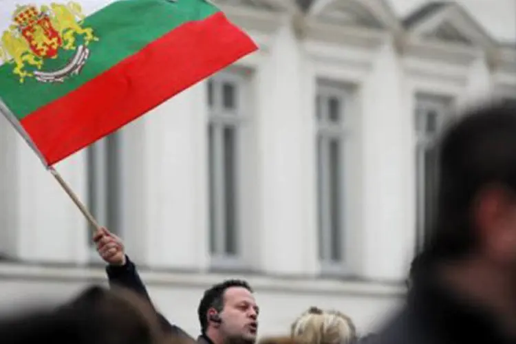 
	Homem agita uma bandeira da Bulg&aacute;ria em frente ao Parlamento: pa&iacute;s est&aacute; dividido
 (Nikolay Doychinov/AFP)