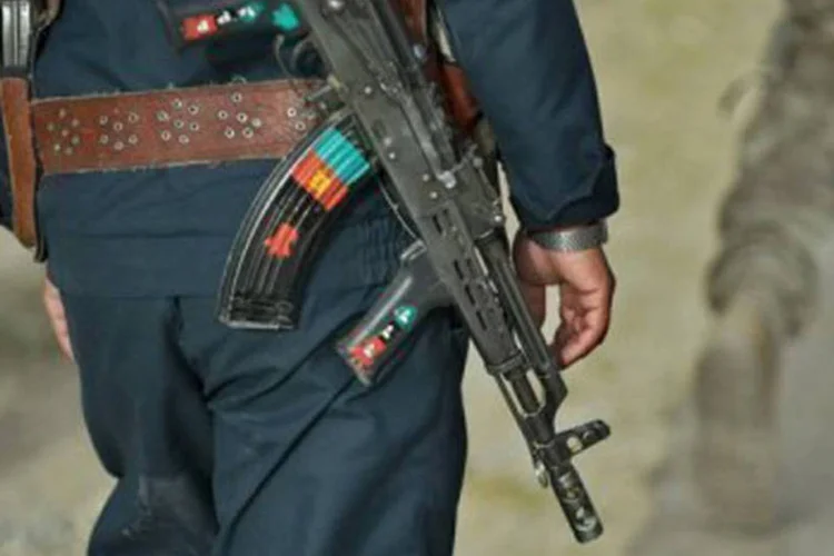 Funcionário da segurança afegão caminha junto a soldado americano durante a partilhar em Kandahar
 (Tony Karumba/AFP)