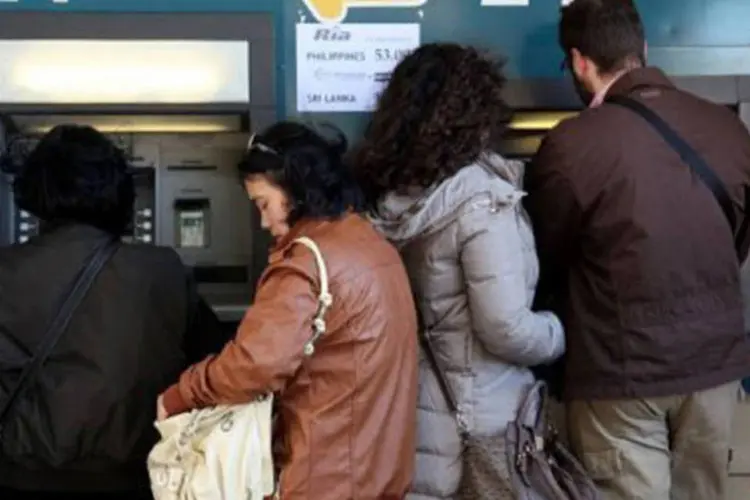 
	Pessoas retiram dinheiro de caixa eletr&ocirc;nico em Nic&oacute;sia, Chipre:&nbsp;h&aacute; filas de entre 20 e 30 pessoas nas caixas do Laiki Bank tentando recuperar seu dinheiro.
 (Barbara Laborde/AFP)