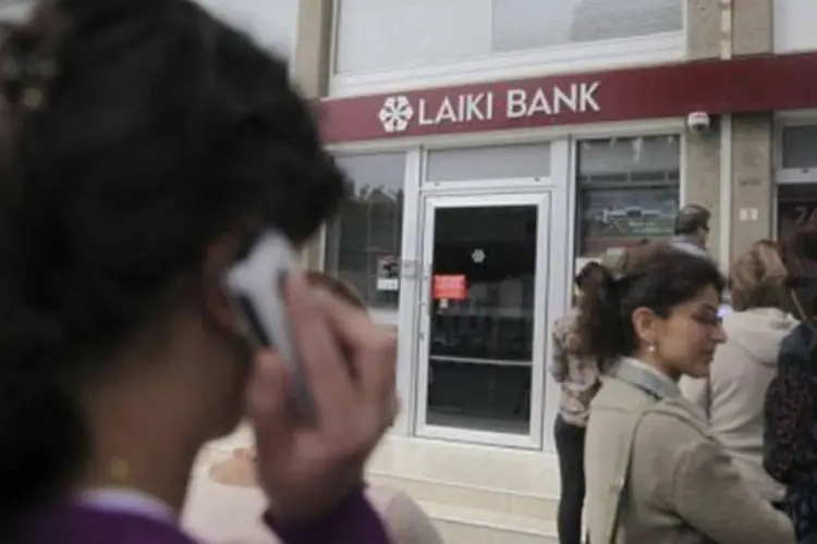 
	Pessoas fazem fila para sacar dinheiro de caixa: Parlamento deve aprovar de qualquer maneira o saneamento do Laiki Bank para ser obtido at&eacute; segunda-feira um acordo global sobre o Chipre
 (Yiannis Kourtoglou/AFP)