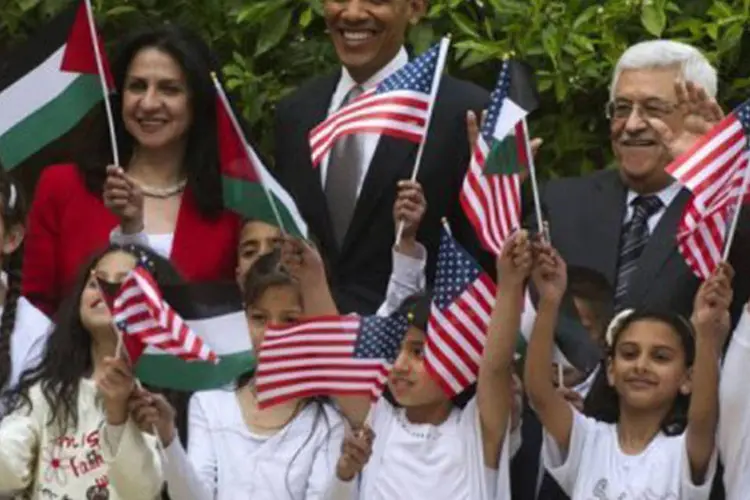 
	Crian&ccedil;as palestinas homenageiam Obama (c) ap&oacute;s a visita do presidente americano &agrave; bas&iacute;lica: em Bel&eacute;m, ele foi recebido pelo presidente palestino, Mahmoud Abbas (d)
 (Saul Loeb/AFP)