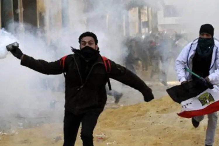 
	Manifestante eg&iacute;pcio lan&ccedil;a bomba de g&aacute;s lacrimog&ecirc;neo durante protesto na Pra&ccedil;a Tahrir, em 25 de janeiro
 (Mohammed Abed)
