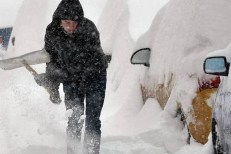 
	Homem limpa uma via de Kiev: muitos ve&iacute;culos seguiam enterrados pela neve nesta segunda-feira
 (Sergei Supinsky/AFP)