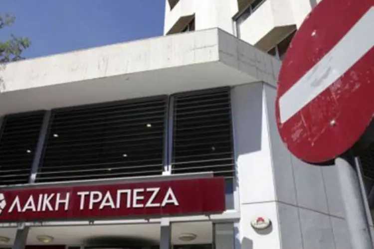 
	Ag&ecirc;ncia do banco Laiki fechada em Nic&oacute;sia: o Banco do Pireu anunciou na ter&ccedil;a-feira a compra por 524 milh&otilde;es de euros de tr&ecirc;s filiais na Gr&eacute;cia de bancos cipriotas
 (Yiannis Kourtoglou/AFP)