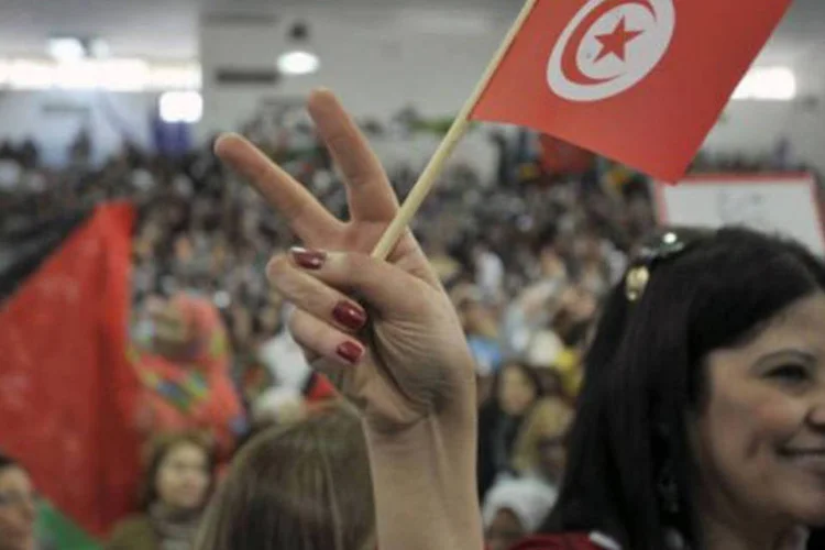 
	Mulher agita a bandeira da Tun&iacute;sia, na abertura do F&oacute;rum Social Mundial: &eacute; a primeira vez que o encontro acontece nesse pa&iacute;s
 (Fethi Belaid/AFP)