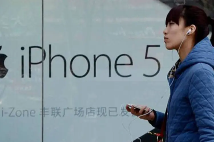 
	Chinesa passa em frente a uma revendedora da Apple em Pequim: a empresa admitiu que ainda tem muito o que aprender acerca da maneira de funcionar e de se comunicar na China
 (Mark Ralston/AFP)