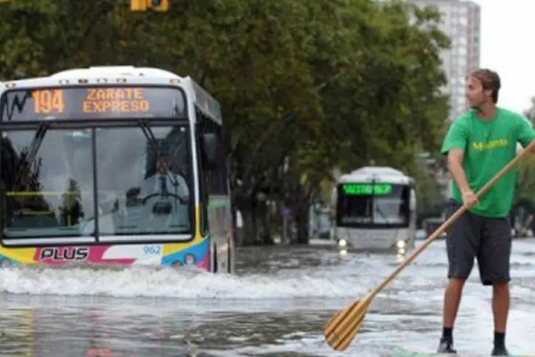 
	Homem rema em uma avenida de Buenos Aires: a chuva de ter&ccedil;a-feira foi um recorde hist&oacute;rico para abril na capital argentina
 (Fernando Sturla/AFP)