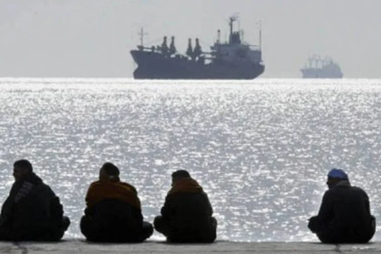 
	Pessoas sentadas em p&iacute;er observam embarca&ccedil;&otilde;es em Safaga, no Egito: os tripulantes do navio foram presos
 (Cris Bouroncle/AFP)