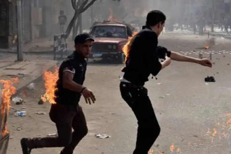 
	Crist&atilde;os coptas tentam retirar roupas em chamas no Cairo em 7 de abril: atos de viol&ecirc;ncia foram registrados no domingo &agrave; noite
 (Mohammed al-Shahed/AFP)