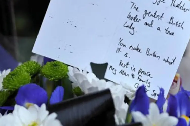 
	Cart&atilde;o e flores em homenagem a Thatcher em frente a sua casa no centro de Londres: &quot;gosto de estar no centro das coisas&quot;, disse em 1984 (Carl Court/AFP)