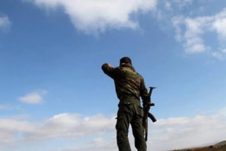 
	Soldado s&iacute;rio observa a cidade de Deraa: a viol&ecirc;ncia deixou nesta quinta-feira ao menos 69 mortos no pa&iacute;s, segundo um balan&ccedil;o provis&oacute;rio do OSDH
 (Anwar Amro/AFP)