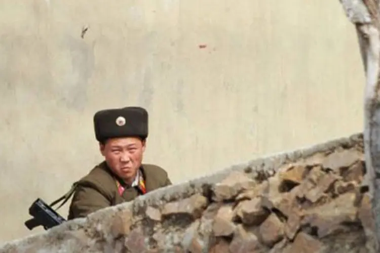 
	Soldado norte-coreano observa a &aacute;rea de fronteira com a China: ignorando as advert&ecirc;ncias da vizinha e aliada China, Pyongyang instalou na semana passada em sua costa oriental dois m&iacute;sseis
 (Wang Zhao/AFP)