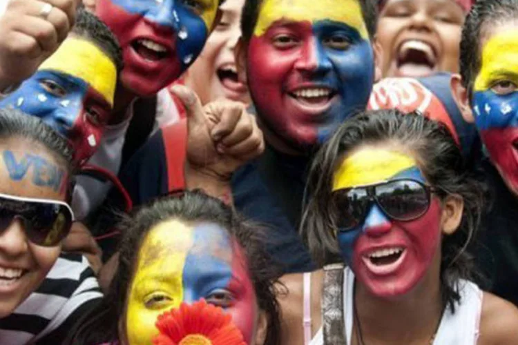 
	Jovens com rostos pintados com as cores da Venezuela manifestam seu apoio a Ch&aacute;vez: Maduro venceu no domingo Henrique Capriles por uma pequena margem (50,66% a 49,07%)
 (Raul Arboleda/AFP)
