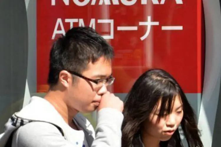 
	Japoneses passam em frente ao banco Nomura: a apreens&atilde;o responde a suspeitas de fraude &agrave;s custas do Banca Monte dei Paschi di Siena
 (Yoshikazu Tsuno/AFP)