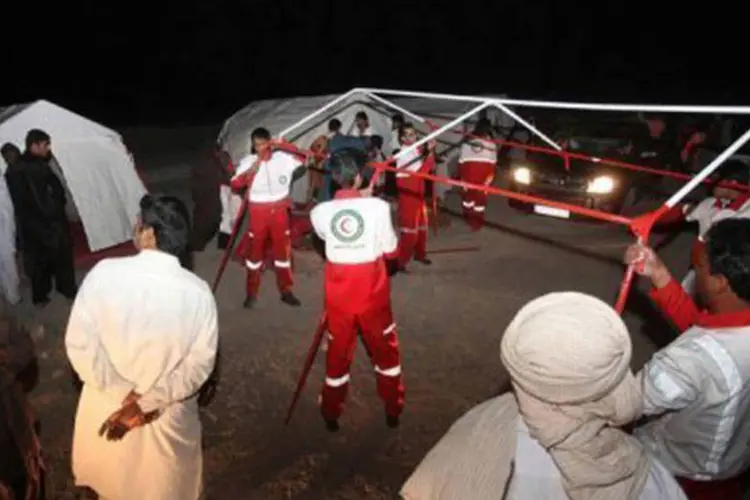 
	Funcion&aacute;rios do Crescente Vermelho erguem tendas para v&iacute;timas de terremoto na cidade de Saravan: este foi o tremor mais intenso registrado no pa&iacute;s desde 1957
 (Hamid Sadeghi/AFP)