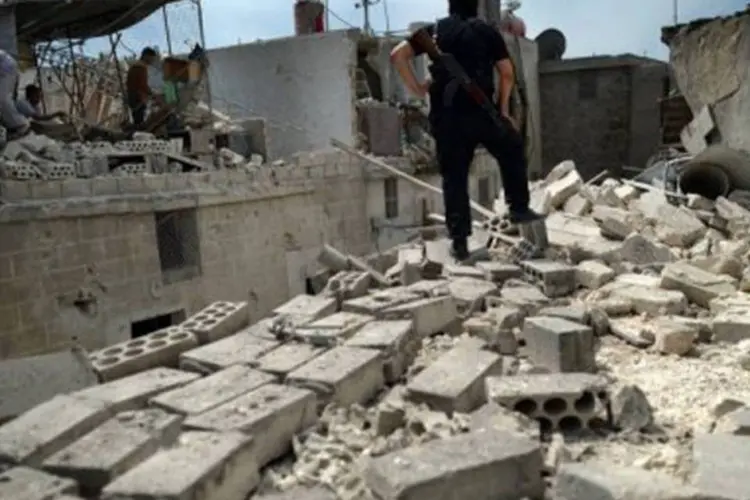 Sírios observam construções destruídas em Alepo após ataque das forças de segurança do país
 (Dimitar Dilkoff/AFP)