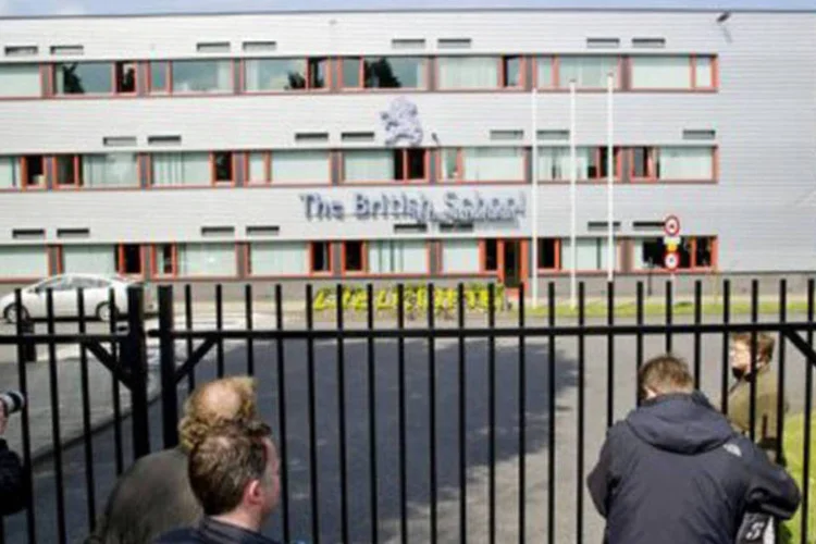 
	Jornalistas em frente &agrave; Escola Brit&acirc;nica de Voorschoten: policiais armados foram enviados para as escolas da cidade
 (Marcel Antonisse/AFP)