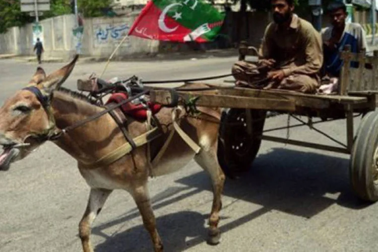 
	Paquistaneses em charrete com bandeira do Partido Tehreek-e-Insaaf em Karachi: a viol&ecirc;ncia aumentou consideravelmente no Paquist&atilde;o antes das elei&ccedil;&otilde;es
 (Rizwan Tabassum/AFP)