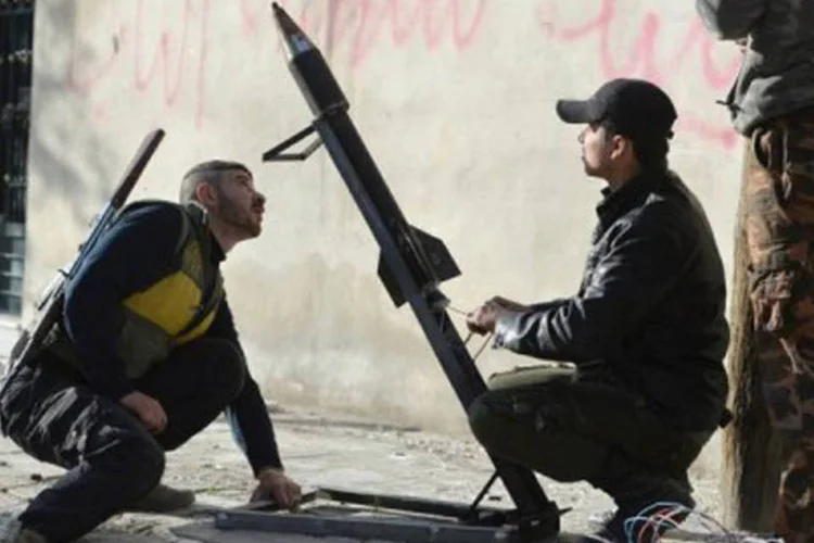 
	Rebeldes s&iacute;rios preparam um foguete, em Alepo:&nbsp;o regime s&iacute;rio rejeita qualquer solu&ccedil;&atilde;o que implique uma sa&iacute;da de Assad do poder
 (Miguel Medina/AFP)