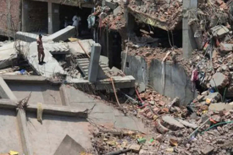 
	Bombeiro entre os escombros do pr&eacute;dio: mais de 500 pessoas morreram
 (Munir Uz Zaman/AFP)
