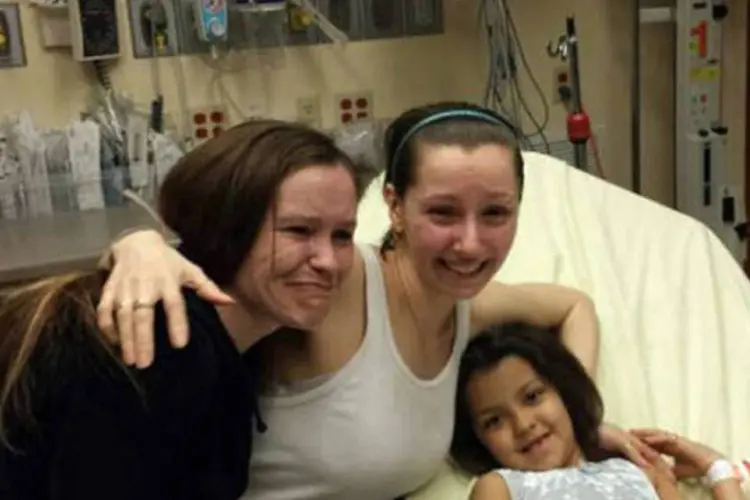 
	Amanda Berry (C), ao lado da irm&atilde; (E) e de uma crian&ccedil;a n&atilde;o identificada em um hospital de Cleveland, Ohio: Amanda foi a primeira a escapar
 (AFP)