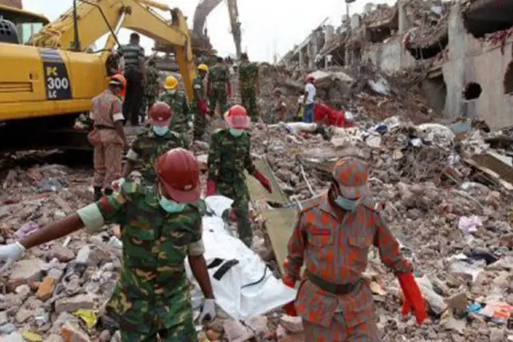 Equipes de resgate de Bangladesh carregam vítima de desabamento de prédio: o edifício desabou no dia 24 de abril quando quase 3.000 pessoas trabalhavam no local
 (AFP)