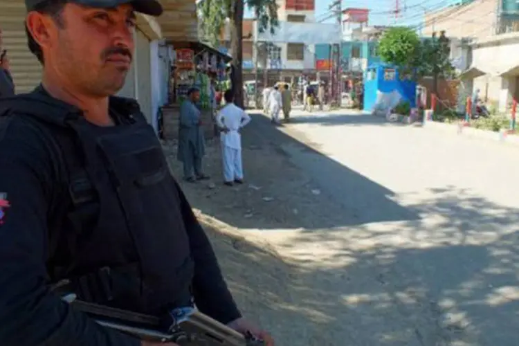 
	Policial paquistan&ecirc;s diante de hospital no distrito de Bannu: um policial e uma mulher morreram
 (Karim Ullah/AFP)
