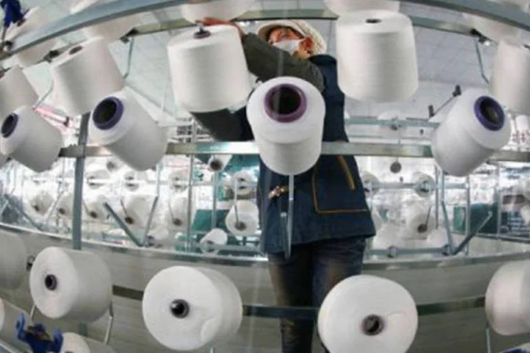 
	Mulher trabalha em f&aacute;brica t&ecirc;xtil em Jiujiang, na China
 (AFP)