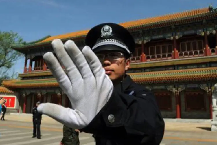 Policial chinês proíbe fotos em frente à sede do Partido Comunista em Pequim em abril de 2012
 (Mark Ralston/AFP)