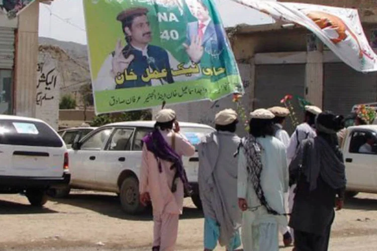 
	Paquistaneses armados caminham diante de local de vota&ccedil;&atilde;o em Miranshah: as bombas estavam perto dos escrit&oacute;rios de candidatos locais &agrave;s elei&ccedil;&otilde;es de s&aacute;bado
 (Thir Khan/AFP)