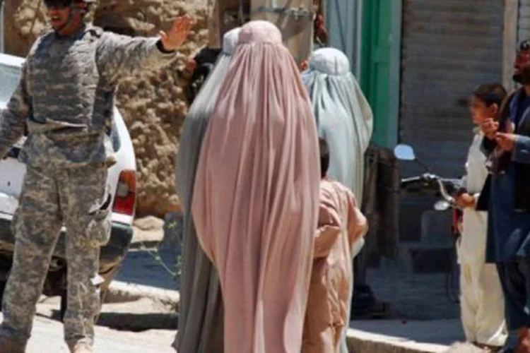 
	Soldado americano e mulheres afeg&atilde;s perto de complexo do governo em Kandahar: o n&uacute;mero de mortos civis no atentado &eacute; o maior no Afeganist&atilde;o desde dezembro
 (Jangir/AFP)