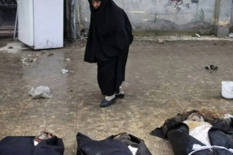 
	Mulher observa corpos de civis executados em Alepo
 (J.M. López)