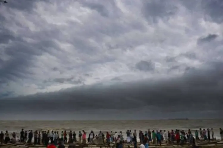 
	Habitantes de Bangladesh se re&uacute;nem para observar chegada do ciclone: nas pr&oacute;ximas horas o ciclone dever&aacute; deixar Bangladesh at&eacute; o final do dia e chegar &agrave; vizinha Mianmar
 (Munir Uz Zaman/AFP)