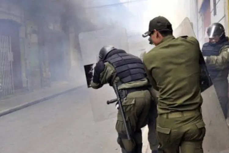 
	Policiais enfrentam manifestantes em La Paz: mineiros usaram dinamite no embate com for&ccedil;as de seguran&ccedil;a. Pol&iacute;cia respondeu com balas de borracha e g&aacute;s lacrimog&ecirc;neo
 (Aizar Raldes/AFP)