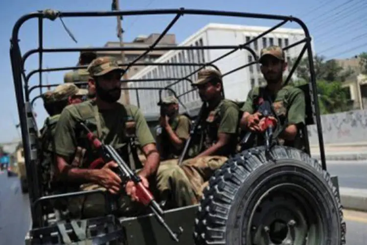 
	Soldados passam em ve&iacute;culo militar por rua de Karachi: a pol&iacute;cia informou que utilizou os registros dos celulares para rastrear os bandidos e encontrar o esconderijo
 (Asif Hassan/AFP)