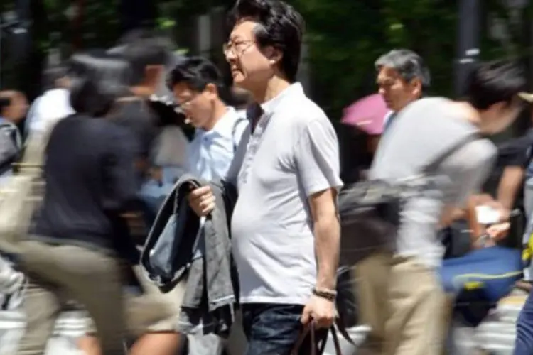 
	Pedestres caminham em T&oacute;quio: a taxa de desemprego permaneceu est&aacute;vel, com 4,1%, ou seja, a mais baixa desde novembro de 2008
 (Yoshikazu Tsuno/AFP)