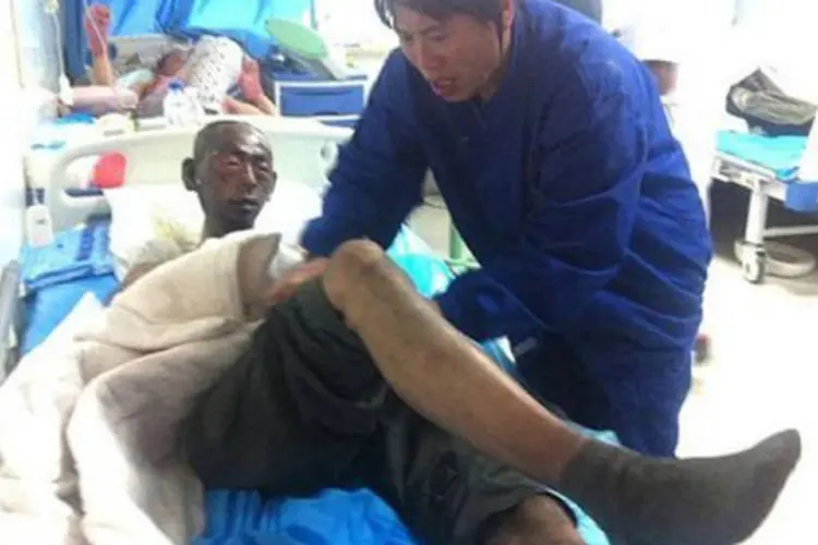 
	V&iacute;tima recebe atendimento em hospital depois de ser resgatada do inc&ecirc;ndio: cem pessoas conseguiram escapar
 (AFP)