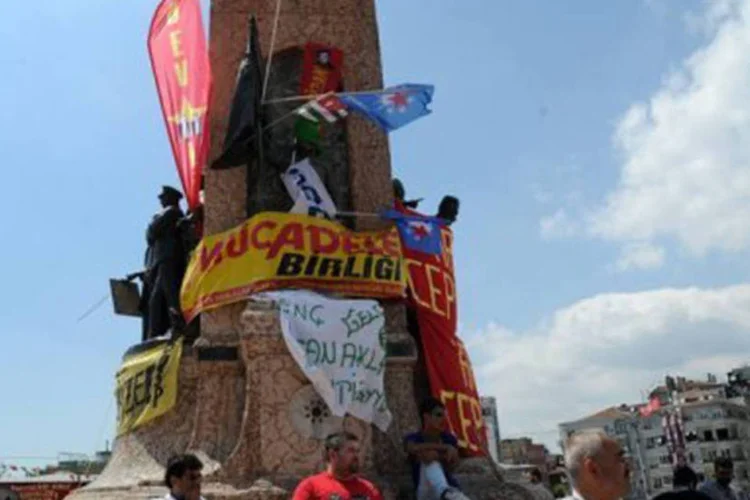 
	Manifestantes em torno do monumento &agrave; Rep&uacute;blica, na pra&ccedil;a Taksim, em Istambul, depois de quatro dias de protestos: quase 500 pessoas foram detidas
 (Bulent Kilic/AFP)