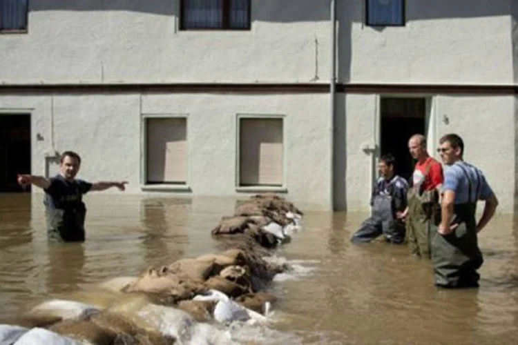 
	Pessoas instalam barreira com sacos de areia na Alemanha: a cat&aacute;strofe deixou ao menos 12 mortos nos &uacute;ltimos cinco dias na Europa Central
 (Odd Andersen/AFP)