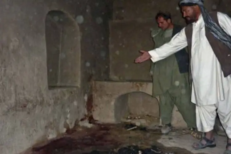 Moradores mostram o local onde uma família foi massacrada dentro de casa pelo soldado
 (Mamoon Durrani/AFP)