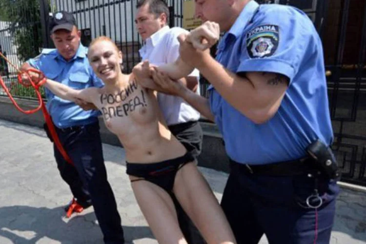 
	Policial russo prende a ativista do Femen: ela trazia escrito em suas costas e no peito &quot;Pra frente R&uacute;ssia&quot;
 (Sergei Supinsky/AFP)