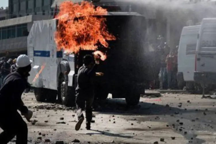 
	Um manifestante joga coquetel Molotov na pol&iacute;cia turca durante confronto na pra&ccedil;a Taksim, em Istambul: as manifesta&ccedil;&otilde;es deixaram quatro mortos, tr&ecirc;s ativistas e um policial (Aris Messinis/AFP)