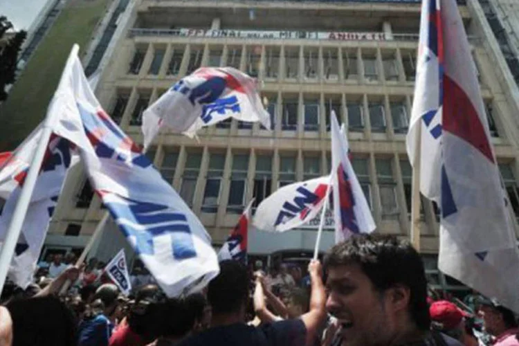 
	Manifestantes reunidos em frente &agrave; TV p&uacute;blica ERT, em Atenas: a decis&atilde;o foi anunciada um dia depois de o governo fechar de maneira fulminante a ERT
 (Louisa Gouliamaki/AFP)