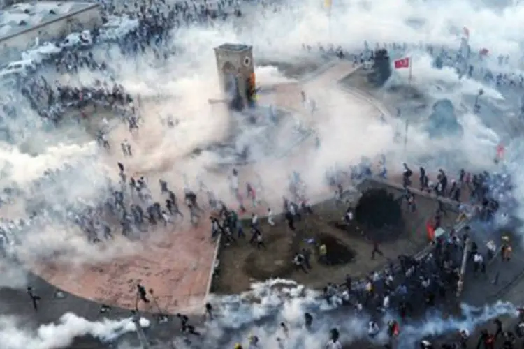 
	Manifestantes correm enquanto a pol&iacute;cia turca lan&ccedil;a g&aacute;s lacrimog&ecirc;neo: a UE criticou o&nbsp;&quot;uso intensivo de canh&otilde;es de &aacute;gua e de g&aacute;s lacrimog&ecirc;neo&quot;
 (Bulent Kilic/AFP)