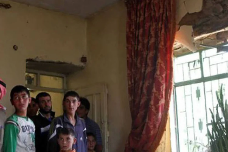 
	Casa atingida por um foguete disparado por um helic&oacute;ptero s&iacute;rio, no vilarejo liban&ecirc;s de Arsal: a localidade sunita apoia a rebeli&atilde;o e tamb&eacute;m &eacute; um lugar de tr&acirc;nsito para armas
 (AFP)