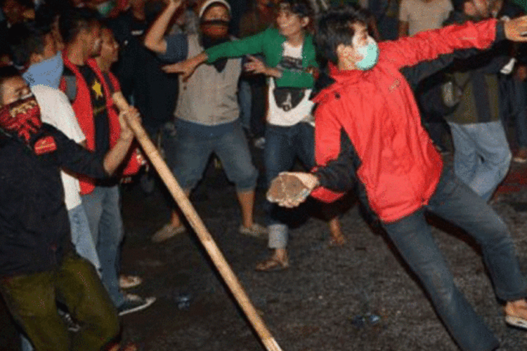 Estudantes atiram pedras contra a polícia, em frente ao parlamento: milhares de indonésios protestaram nesta segunda-feira contra o aumento do preço dos combustíveis, (Adek Berry/AFP)