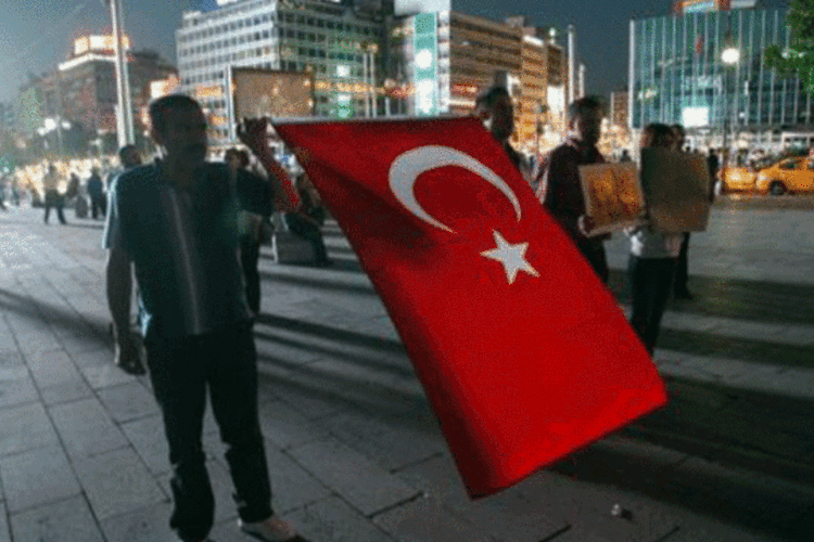 Manifestantes turcos seguram uma bandeira do país em Ancara: polícia turca prendeu na terça-feira dezenas de membros do ESP e revistou sedes de jornais ligados ao partido (Adem Altan/AFP)